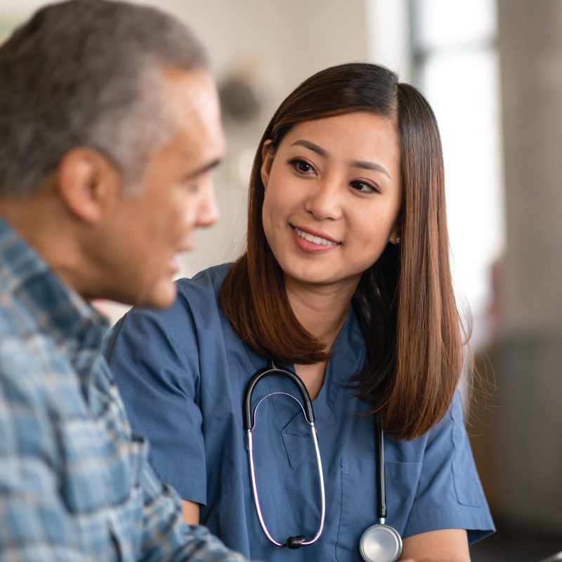 Female physician visiting with a senior man in his Courtyard suite