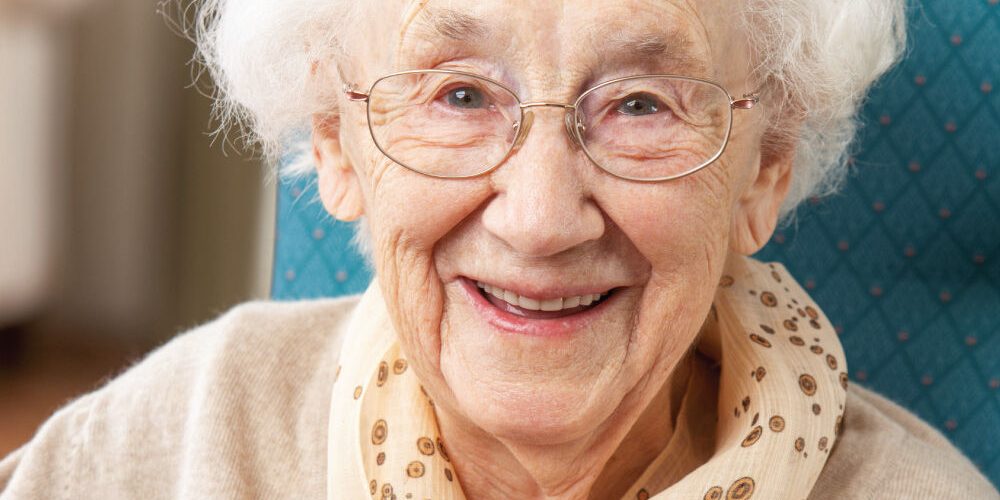 Happy-Senior-Woman-Enjoying-a-Cup-of-Tea Happy Senior Woman drinking a warm cup of tea